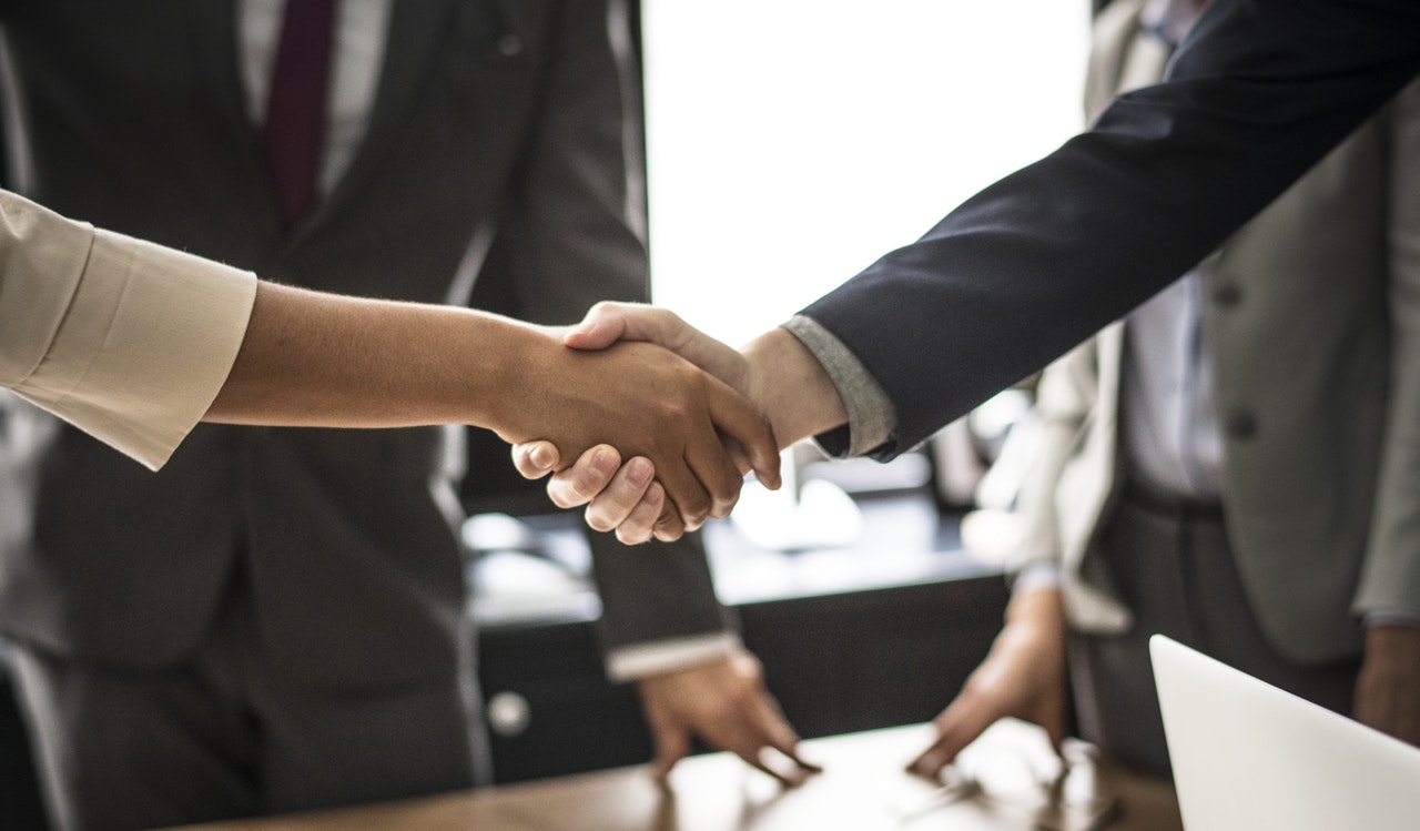 client and outsourcing services agency shaking hands over a deal