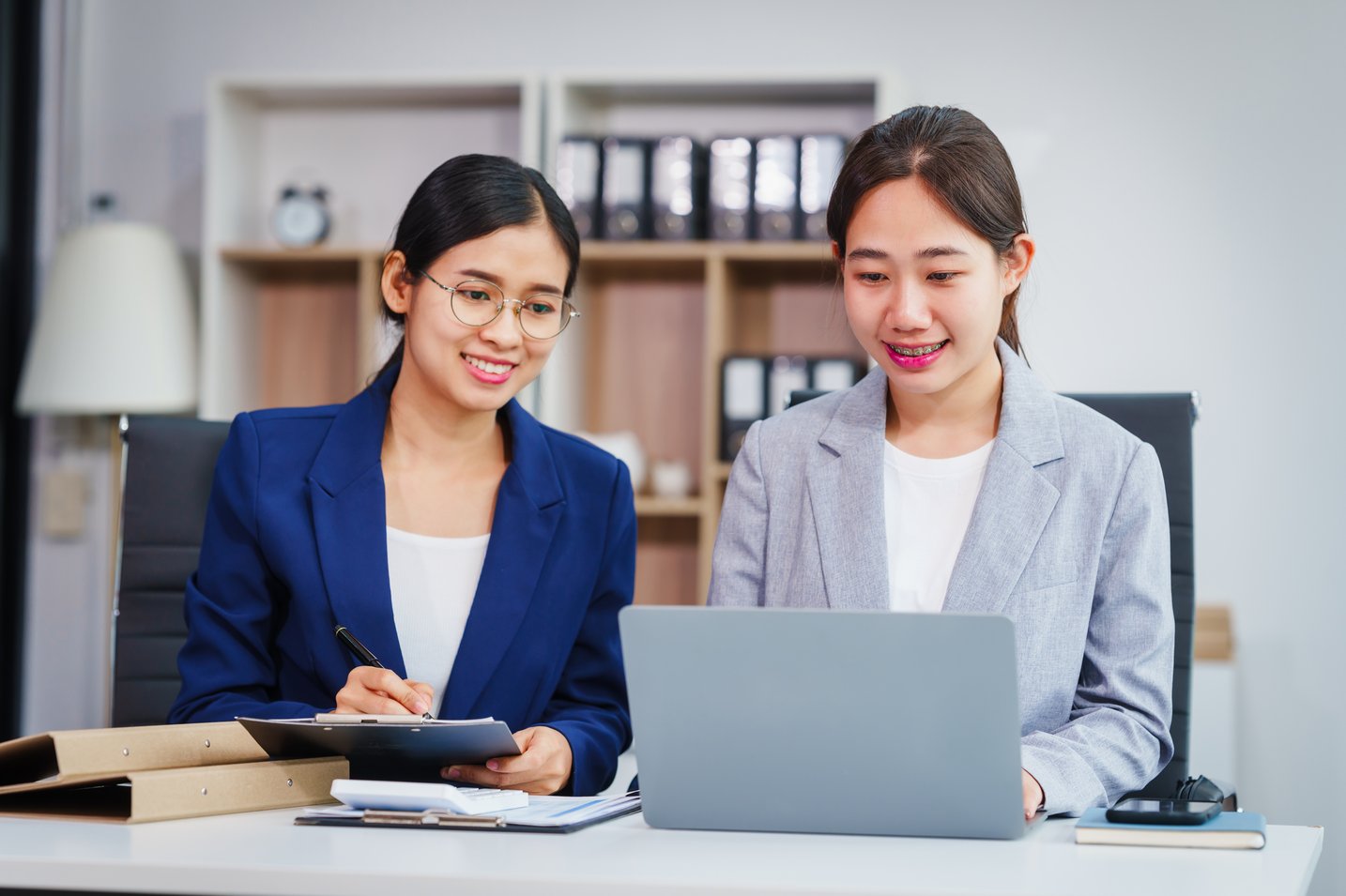 smiling-women-work-together-at-office-desk-2026-01-08-01-23-54-utc