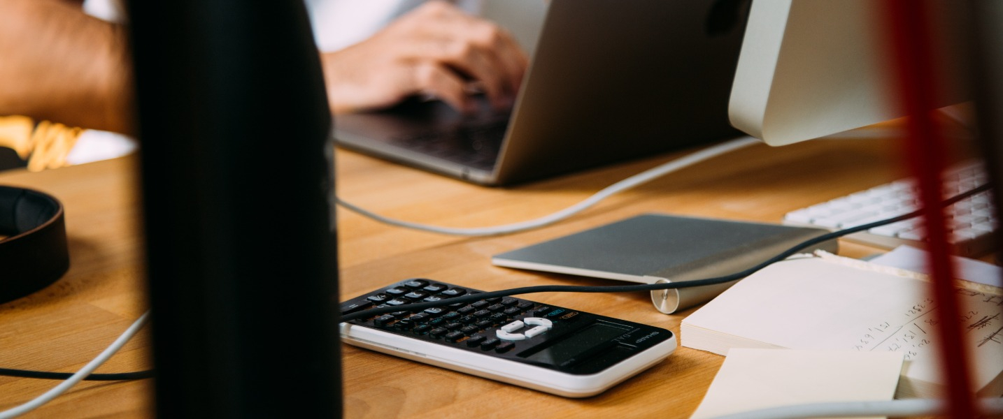 A person using a computer to write, representing the impacts of AI on the accounting profession