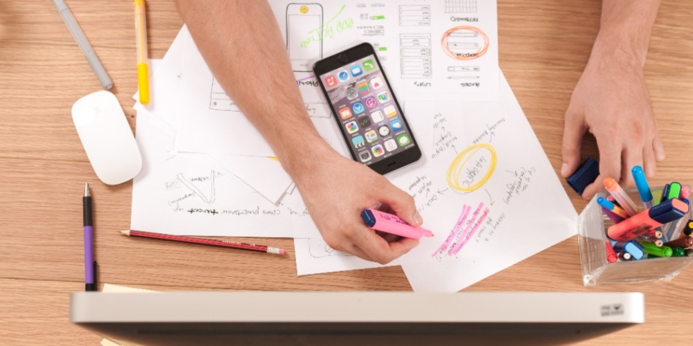 person writing on white paper to differentiate manual process vs. Automated process