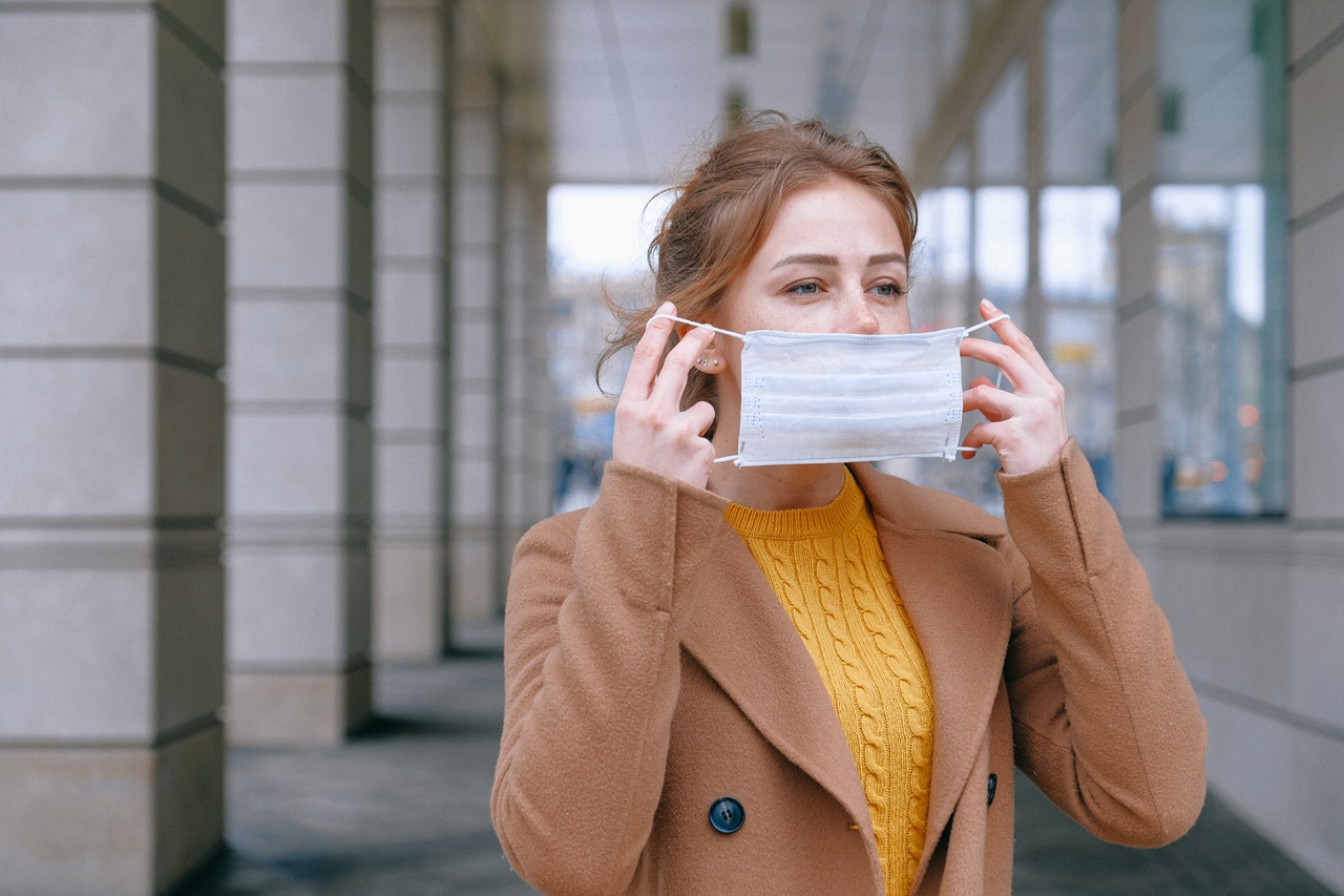 Woman covering face with surgical mask